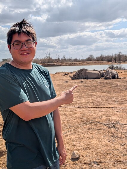 A person pointing at a landscape with a dry riverbed and large rocks. 3