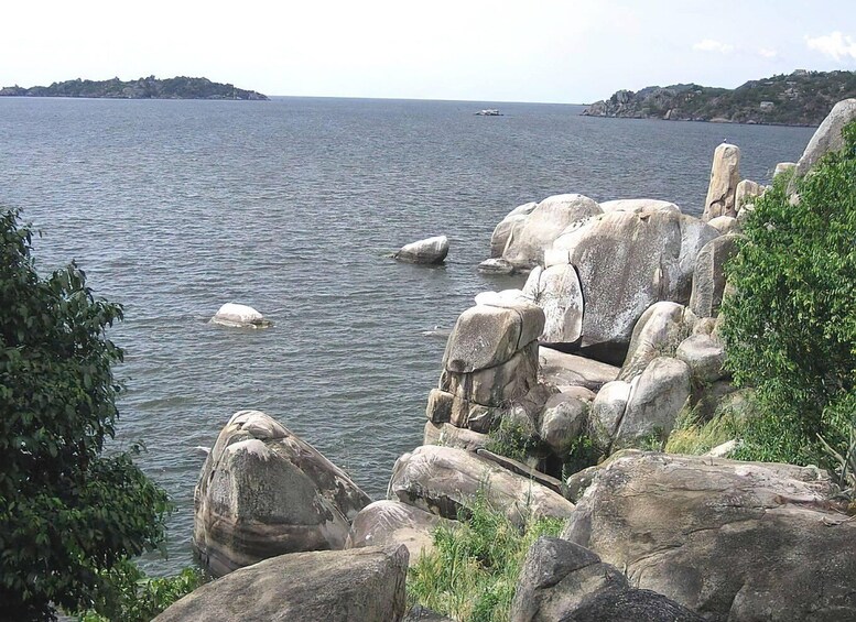 A rocky shoreline with large boulders and calm water. 2