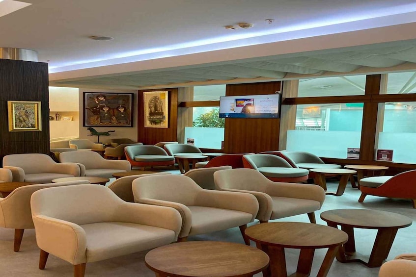 A modern waiting area with leather chairs, wooden tables, and artwork on the walls. 3