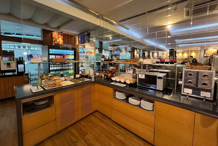 A modern cafe with a counter displaying pastries and beverages, a coffee machine, and a glass display case with snacks. 2