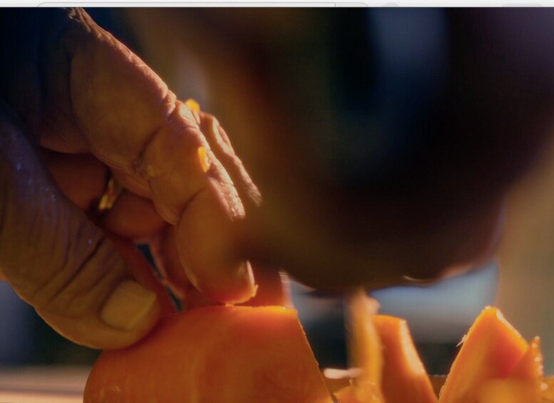 A close-up of hands peeling a carrot. 2