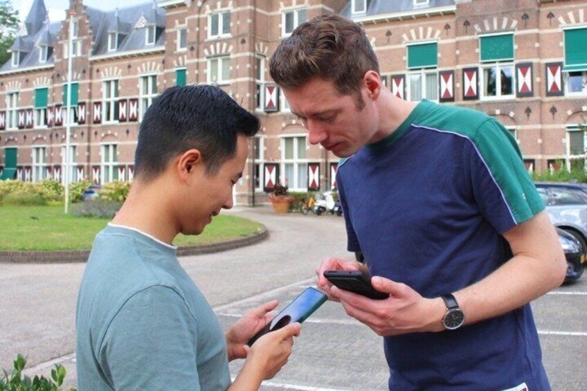 Two people standing outdoors, one holding a smartphone. 3