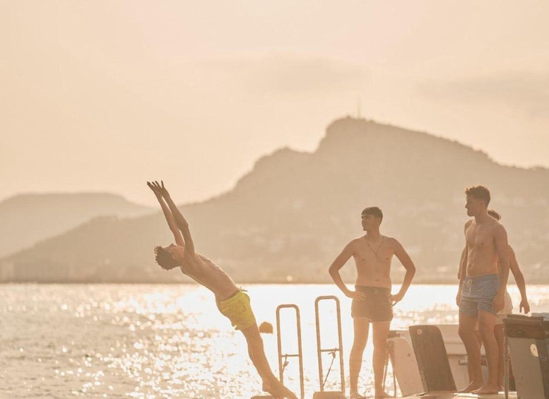 A person diving into the water, with a mountainous landscape in the background. 5