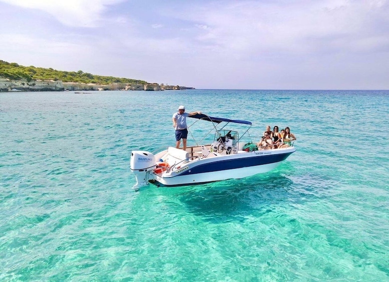 A boat with people on it in clear turquoise water. 1