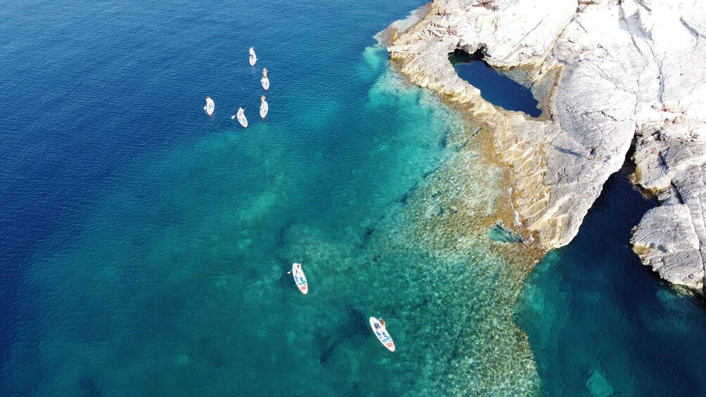 A coastal area with clear turquoise waters and rocky cliffs. 4
