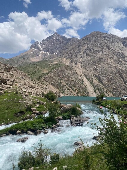 A river flowing through a mountainous landscape with a lake and rocky terrain. 5