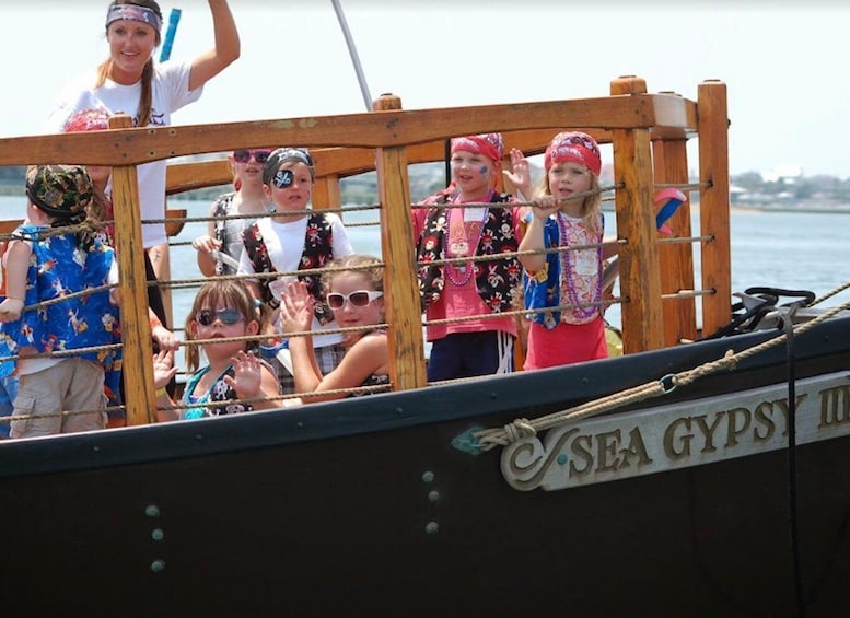 A group of people on a boat with a sign that reads 'SEA GYPSY.' 1