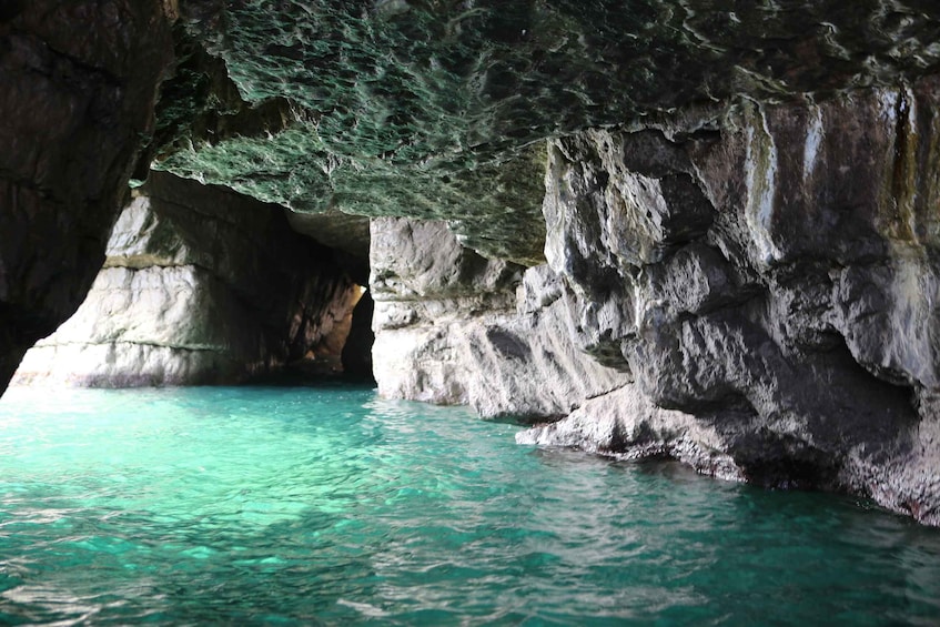 A cave with turquoise water and rocky walls. 1