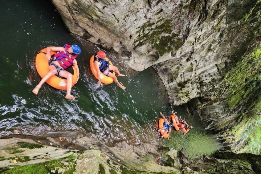People rafting in a narrow canyon with rocky walls and water. 1