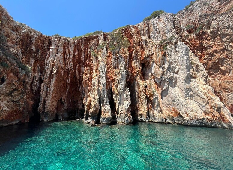 A clear turquoise sea with rocky cliffs. 4