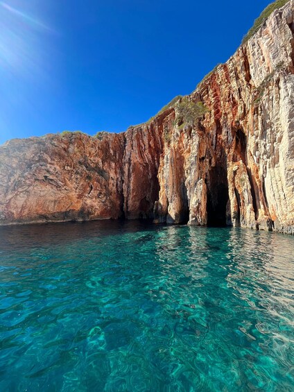A coastal cliff with clear turquoise water. 5