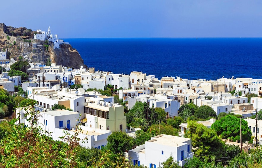 A coastal town with white buildings, a church on a cliff, and the sea. 5