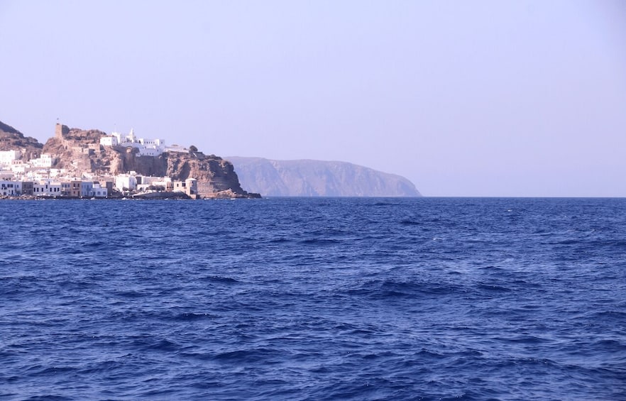 A coastal town with white buildings on a cliff, overlooking the sea. 3