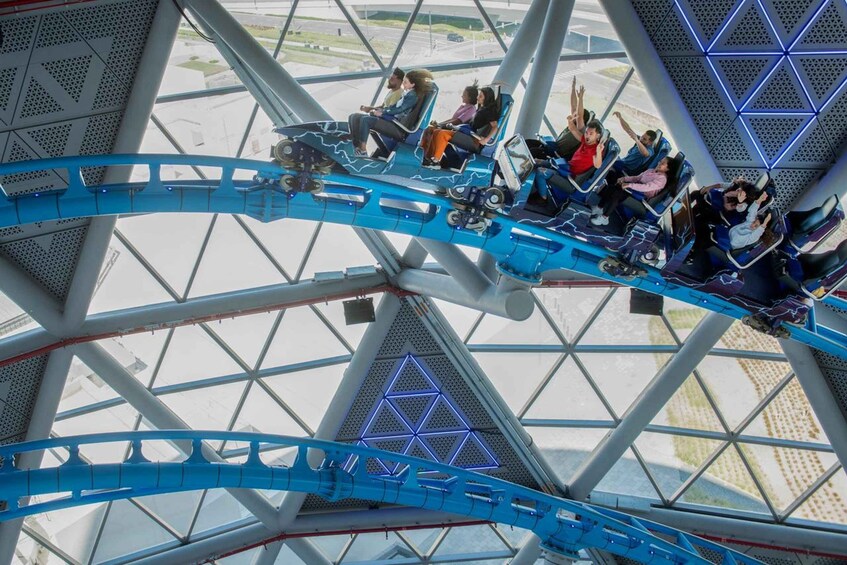 A roller coaster with passengers seated in the cars. 1