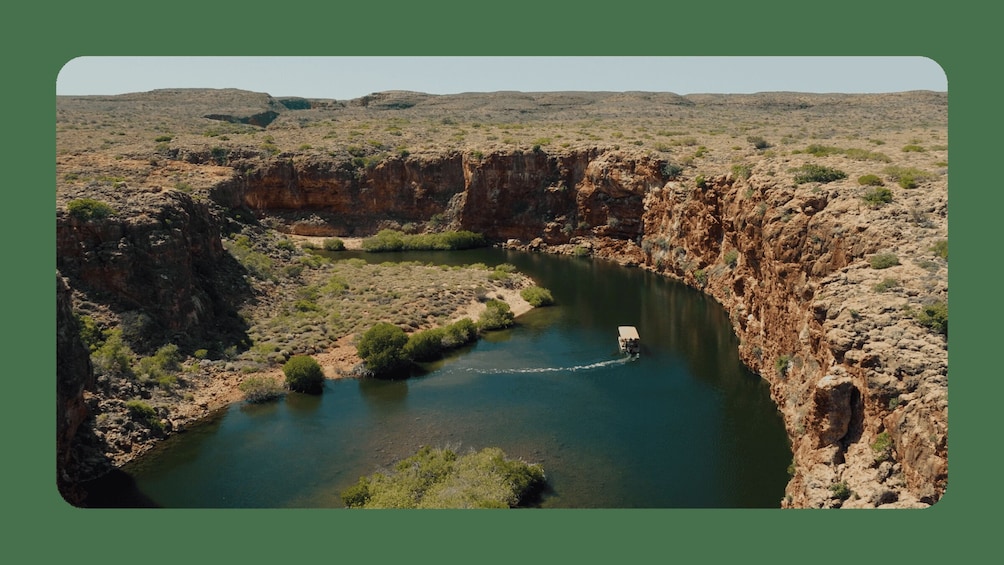 A canyon with a river flowing through it, surrounded by rocky cliffs and sparse vegetation. 1