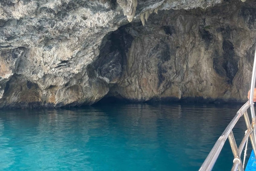 A rocky cave entrance with clear blue water. 3