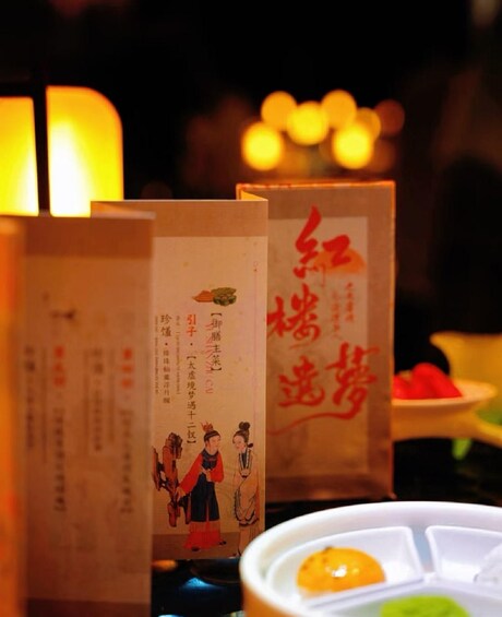 A table with traditional Chinese food items and menus with calligraphy. 4