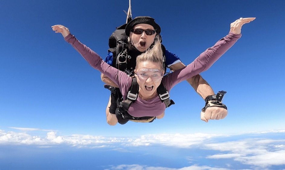 A person skydiving with a parachute, wearing a backpack and goggles. 2