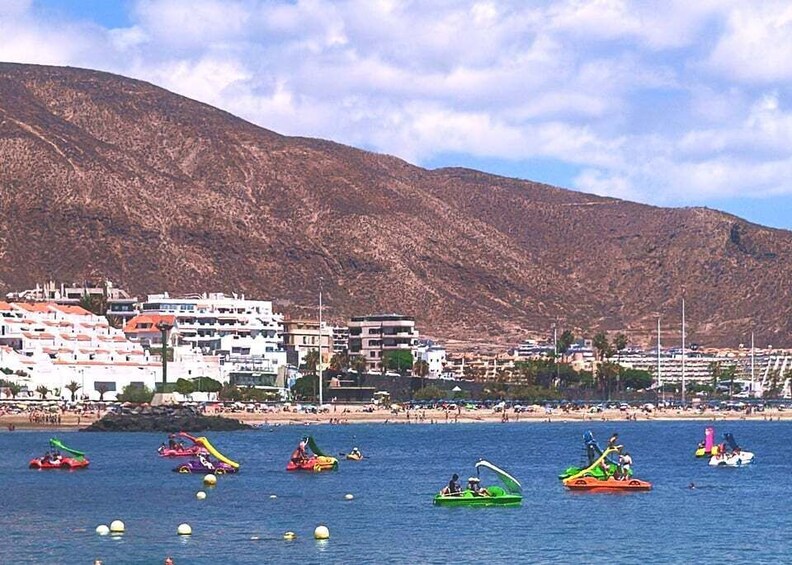 A coastal area with boats, a beach, and buildings in the background. 4