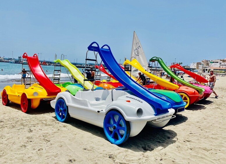 Colorful children's water slides on a beach with a clear sky. 1