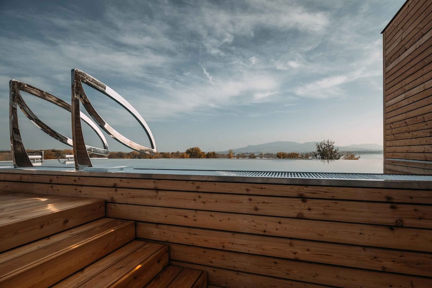 A wooden deck with a view of a lake and mountains. 3