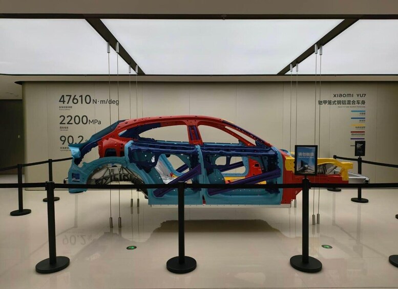 A car's interior frame displayed in a museum with informational signs. 3
