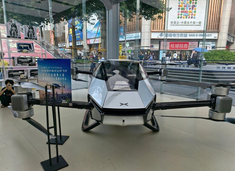 A futuristic vehicle on display with a cityscape background. 2