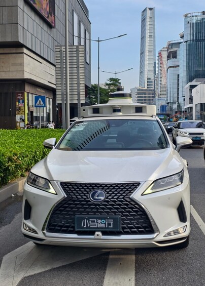 A white Lexus car on a city street with tall buildings in the background. 5