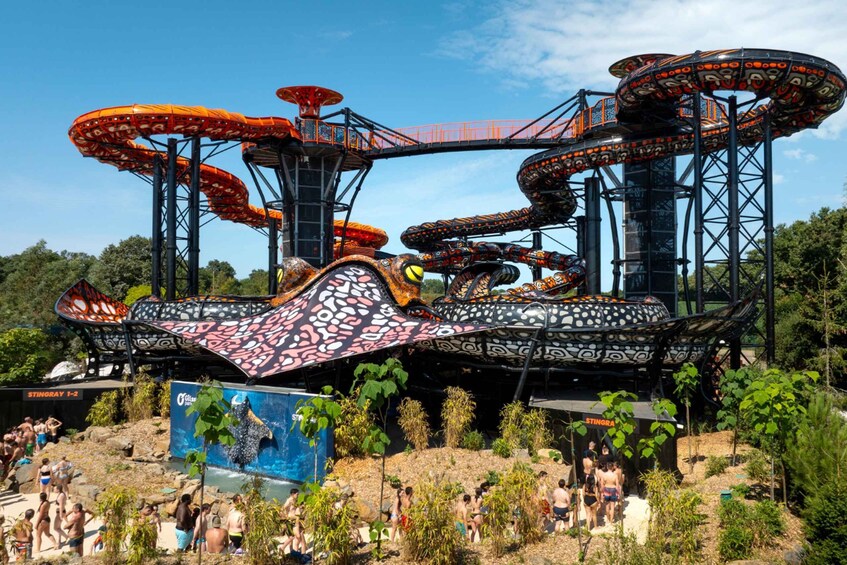 A roller coaster with multiple loops and a large, colorful structure at the base. 1