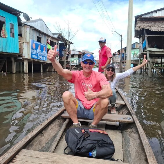 A person in a boat giving a thumbs-up gesture, another person in a pink shirt, and a woman in a white shirt. 4