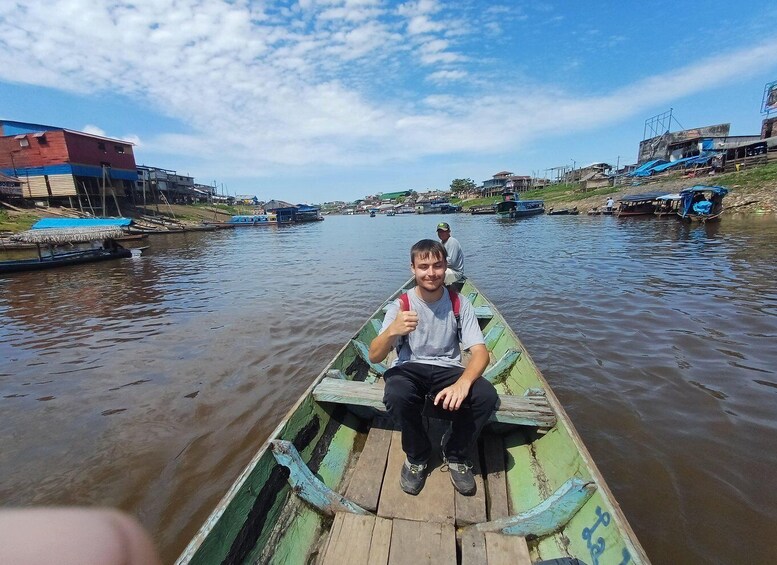 A person in a green boat on a river with buildings on the banks. 2