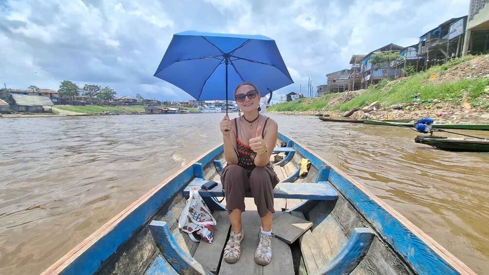 A person in a boat on a river, holding an umbrella. 5