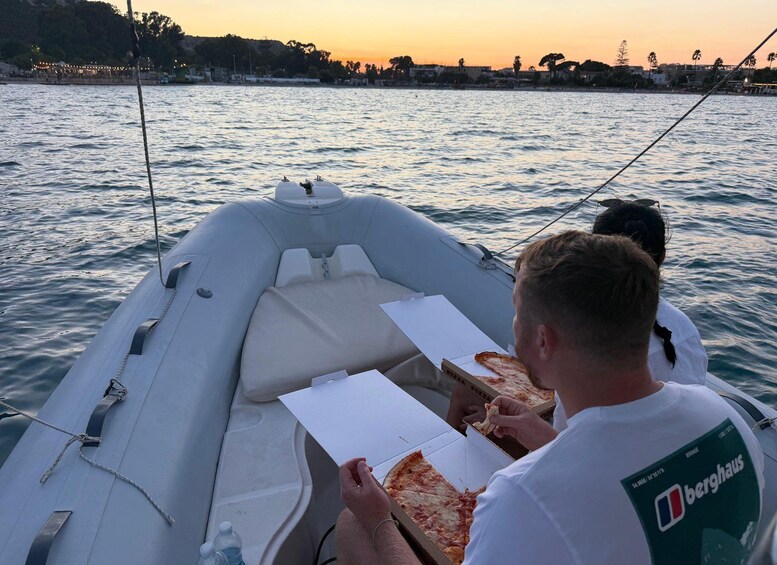 A boat with two people eating pizza. 3