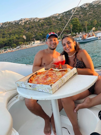 A boat with a table, pizza, and drinks. 5