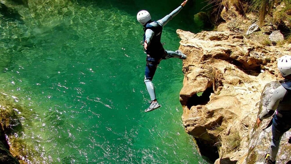 A person bungee jumping from a cliff into a body of water. 4