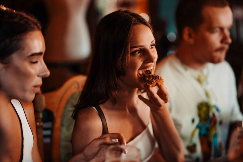 A person holding a food item, likely a pastry, in a casual dining setting. 1
