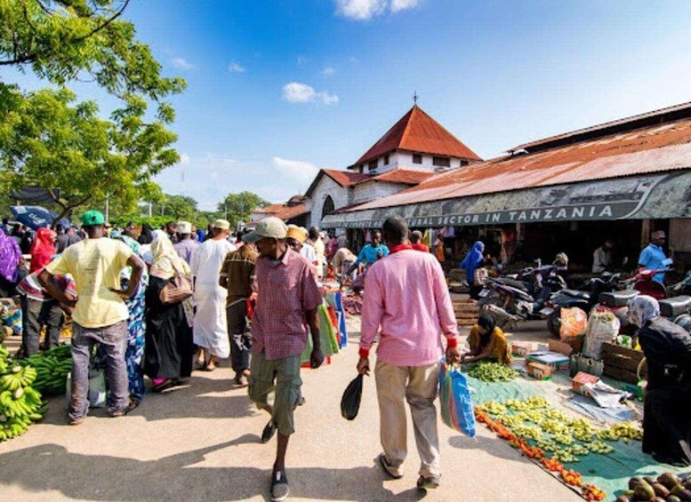A bustling outdoor market with people shopping and vendors selling goods. 2