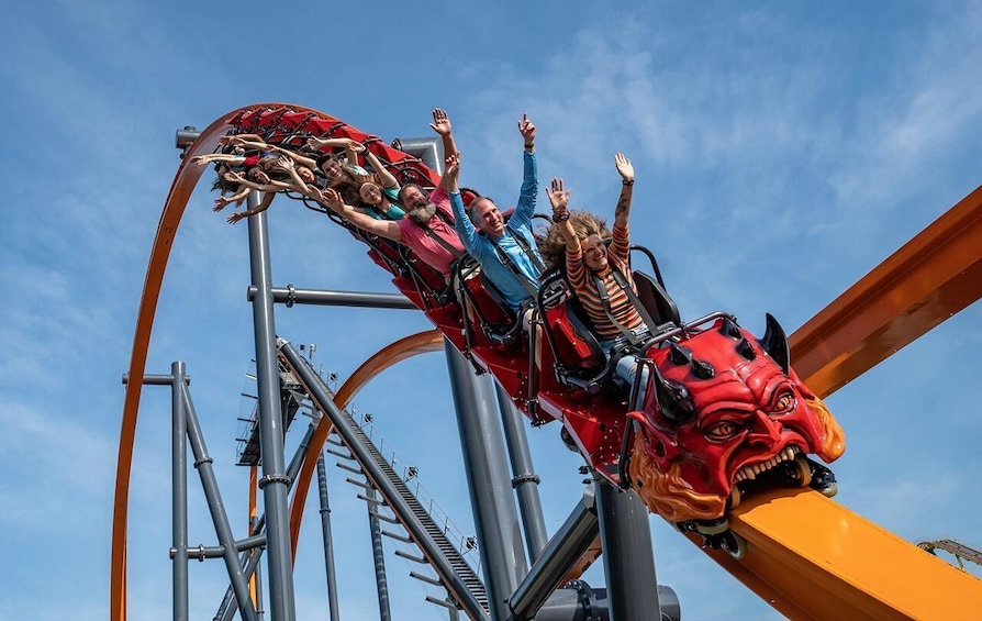 A roller coaster in motion with riders holding onto the sides. 1