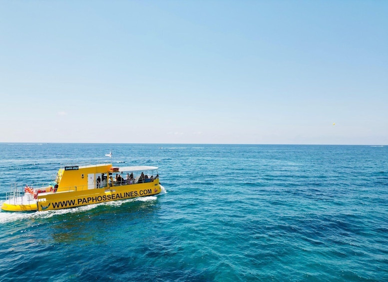 A yellow boat with people on board, sailing on a blue sea. 4