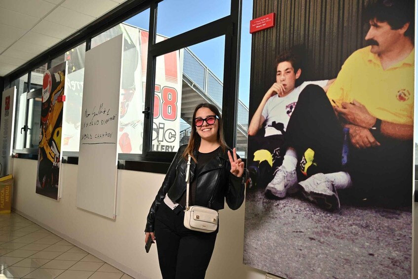 A person standing in a hallway with posters and signs on the walls. 5