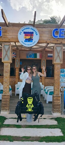 A wooden structure with a sign for the Ft Diving Center, flags, and outdoor seating. 3