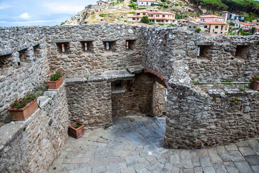 A stone fortress with arched openings and a paved courtyard. 5
