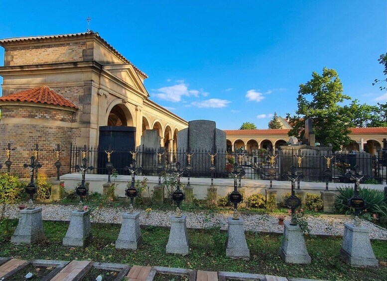 A cemetery with tombstones, a church, and a stone wall. 3