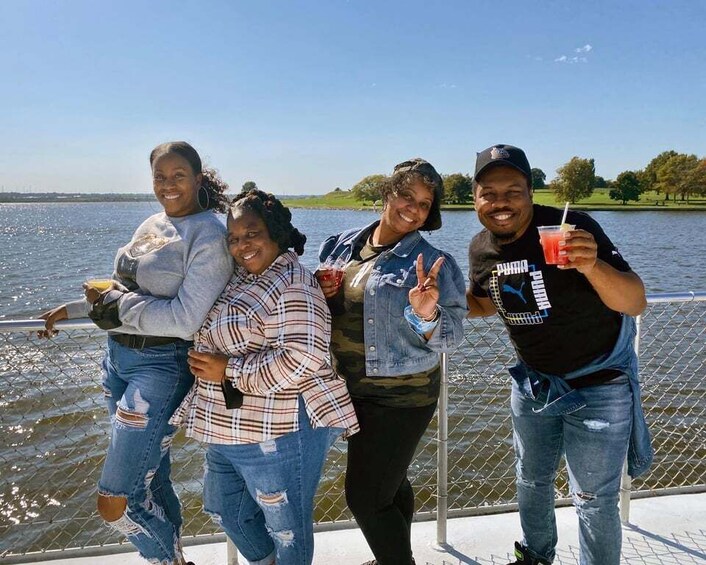 A group of people on a boat with a body of water and a distant shoreline in the background. 4