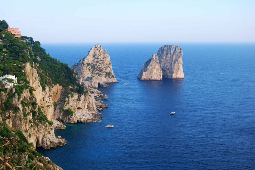 A coastal landscape with rocky cliffs and a clear blue sea. 5