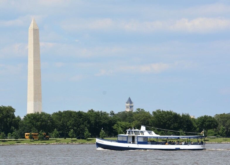 A river with a boat, a large monument, and a tower in the background. 3