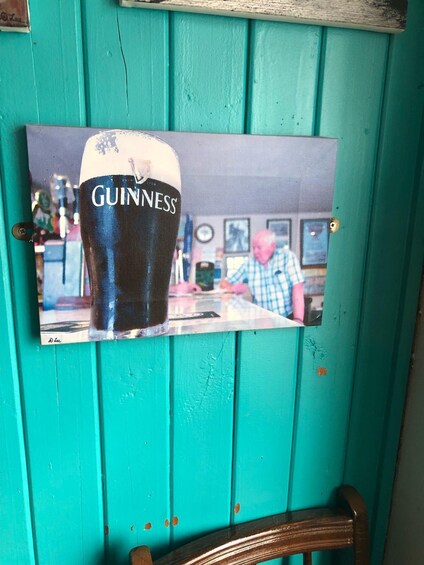 A photograph of a Guinness glass on a teal wooden wall. 5