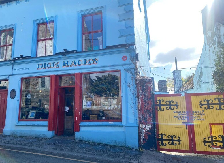 A blue building with a red door and windows, labeled 'Dick Mack's.' 4