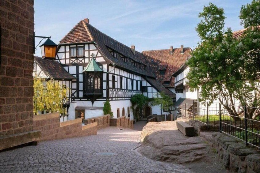 A cobblestone street, traditional half-timbered houses, and a small bridge. 3