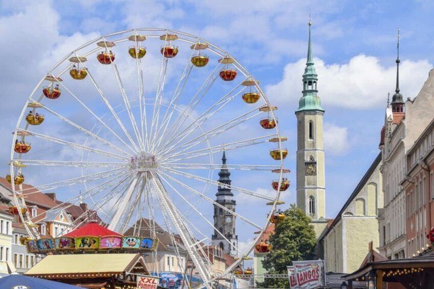 A Ferris wheel, a church tower, and a market street. 5